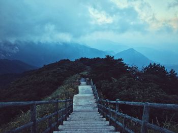 Steps leading towards mountain against sky