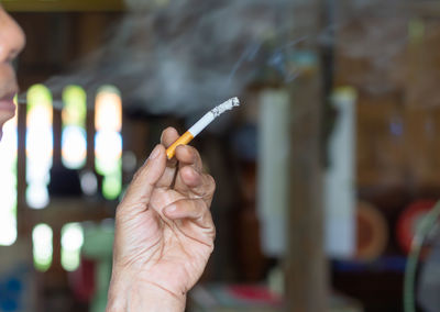 Close-up of hand holding cigarette