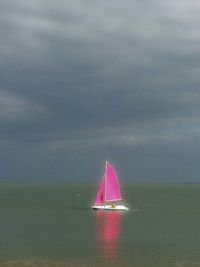 Sailboat sailing in sea against sky