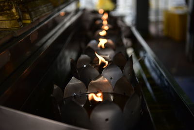 Lit candles in temple against building