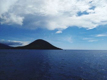 Scenic view of sea and mountains against sky