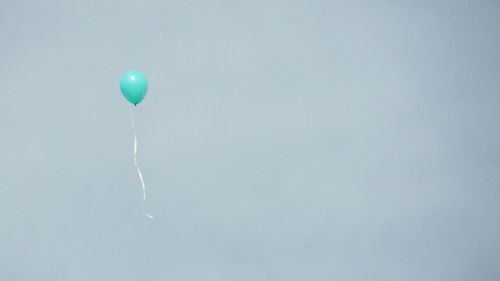 Low angle view of balloons against blue sky