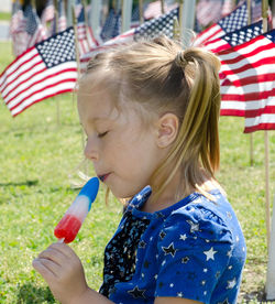 Sweet taste of freedom. a young girl enjoys a red white and blue popsicle on the 4th of july