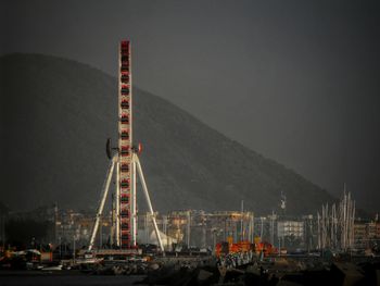 Cranes at harbor against clear sky