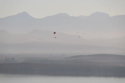 In the early morning mist, a microlight flies with the birds over the bornos reservoir.