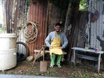 Portrait of young man sitting on wood