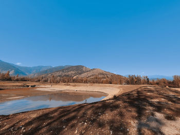 Scenic view of desert against clear blue sky