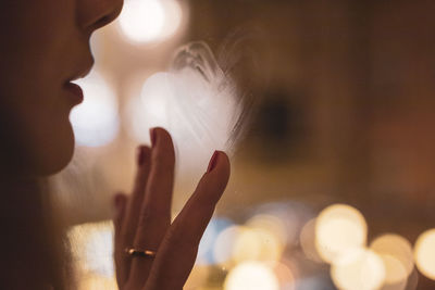 Close-up portrait of woman hand on blurred background