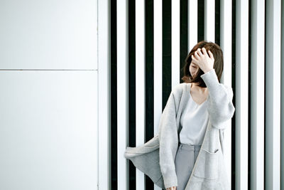 Young woman looking through window