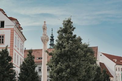 Low angle view of statue against buildings