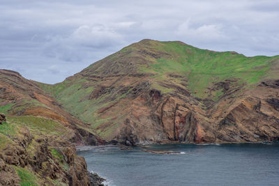 Scenic view of sea and mountains against sky