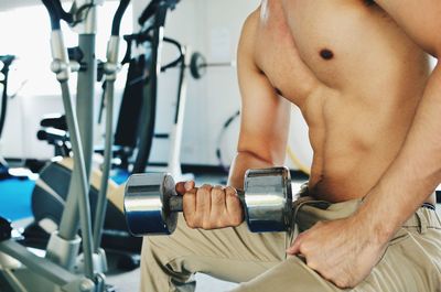 Midsection of man exercising in gym