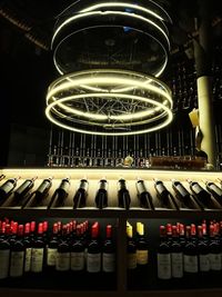 Low angle view of illuminated bottles on display at night