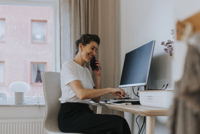 Smiling businesswoman talking via phone