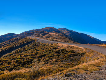 Scenic view of mountains against clear blue sky