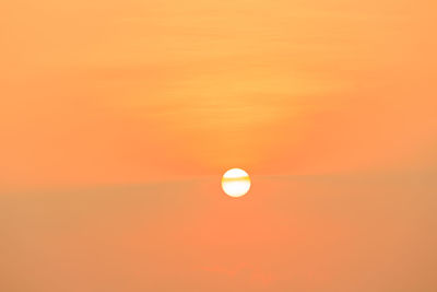 Scenic view of moon against orange sky