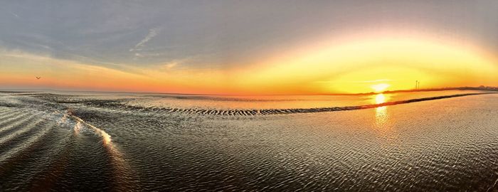 Scenic view of beach against sky during sunset