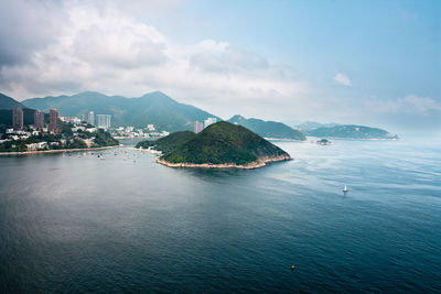 Scenic view of sea by city against sky