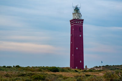 Lighthouse by sea against sky