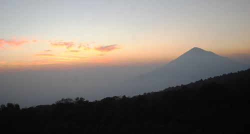 Scenic view of silhouette mountains against sky at sunset