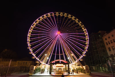 Low angle view of illuminated ferris wheel against sky at night