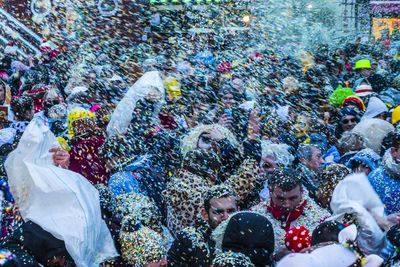 Crowd throwing colorful confetti in city during celebration