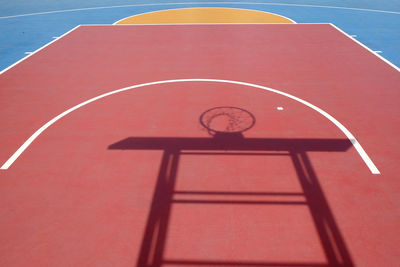 Shadow of basketball hoop on court