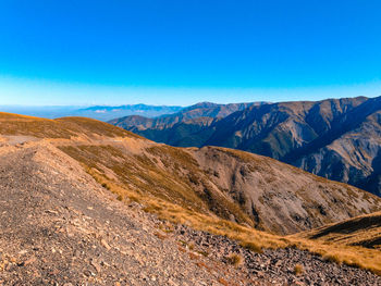 Scenic view of mountains against clear blue sky