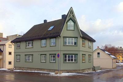 Houses by river against sky