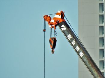 Low angle view of lighting equipment against clear blue sky