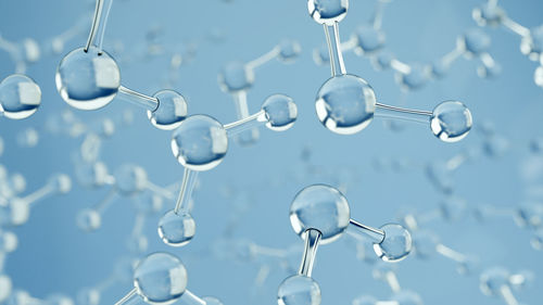 Close-up of water drops on glass against blue background