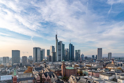 Modern buildings in city against cloudy sky