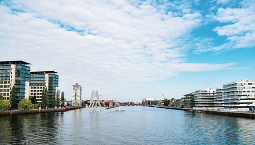 River amidst buildings in city against sky