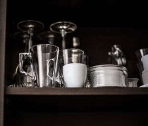 Low angle view of glasses on shelf in kitchen at home