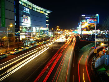 Light trails on road along buildings at night