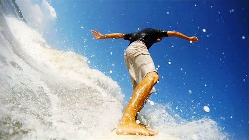 Rear view of woman jumping in water