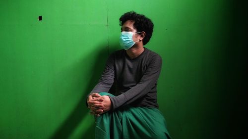 Young man standing against wall