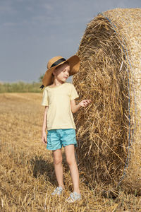 Little girl having fun in a wheat field on a summer day. 