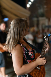 Midsection of woman playing guitar