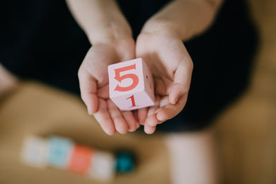 Cropped hands of child holding toy block