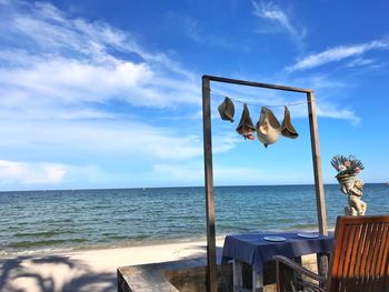 Wooden posts on beach against sky
