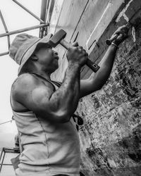 Low angle view of man standing against wall