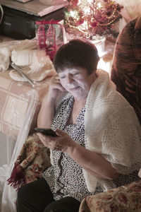 Midsection of woman using mobile phone at home