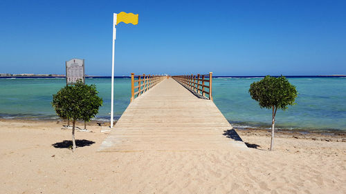 Scenic view of beach against clear blue sky