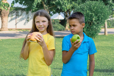 Children schoolchildren eat lunch in the park. harmful and healthy food.