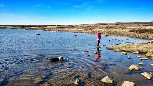 Girl standing on rock in sea