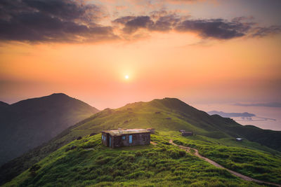 Built structure on field against sky during sunset