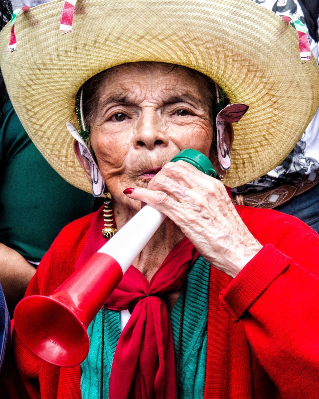 hat, clothing, adult, one person, real people, portrait, headshot, traditional clothing, senior adult, front view, women, looking at camera, holding, red, close-up, mature adult, human body part, lifestyles, human face, sombrero, scarf