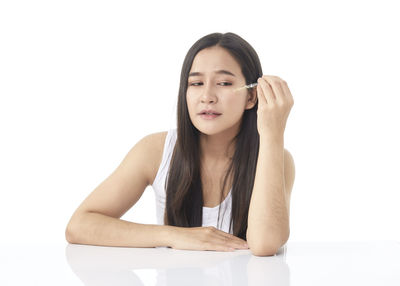 Portrait of a beautiful young woman against white background