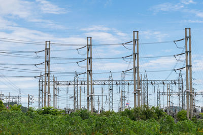 Low angle view of electricity pylon against clear blue sky